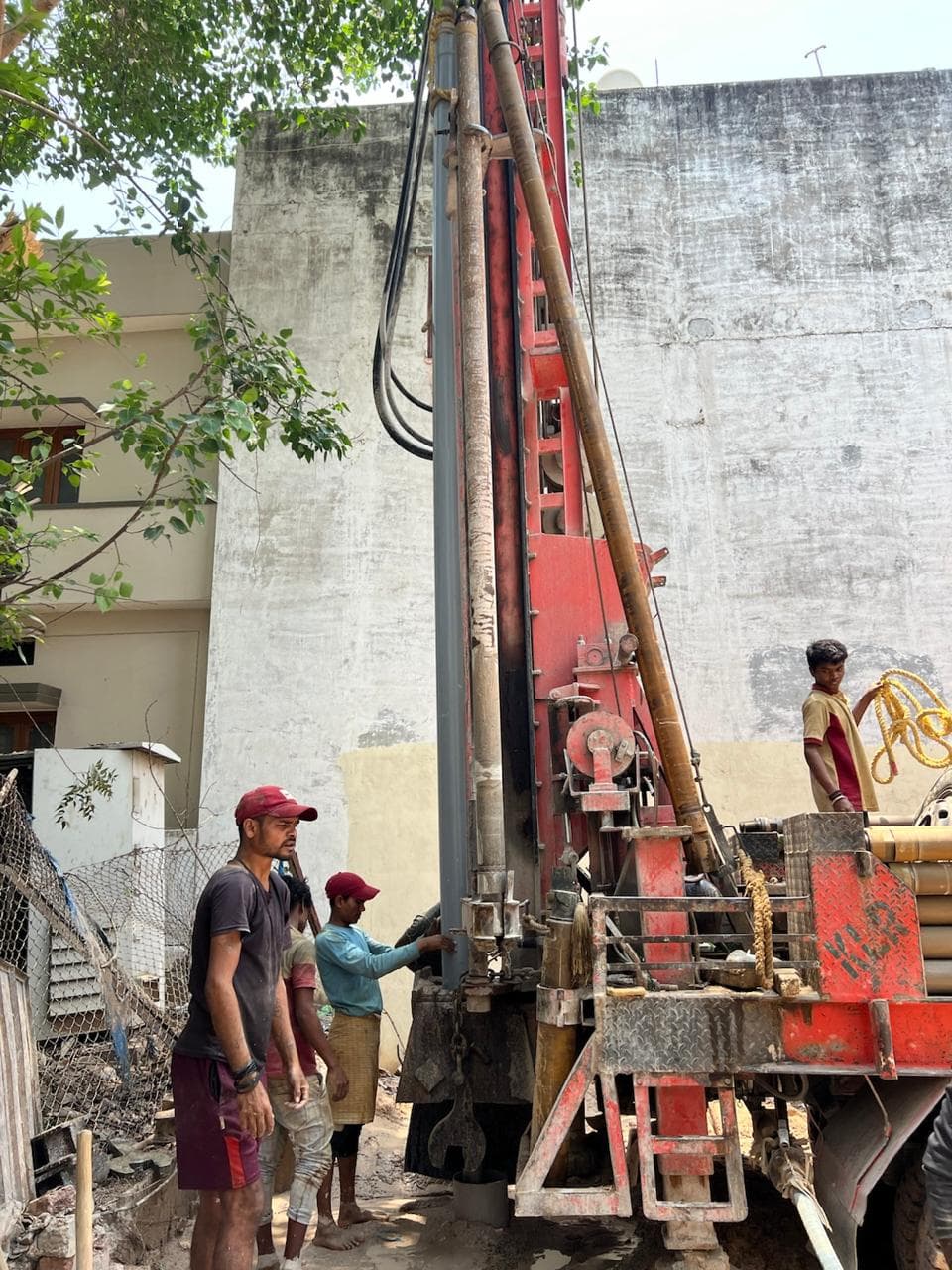 Borewell drilling rig with the site team — June 2025
