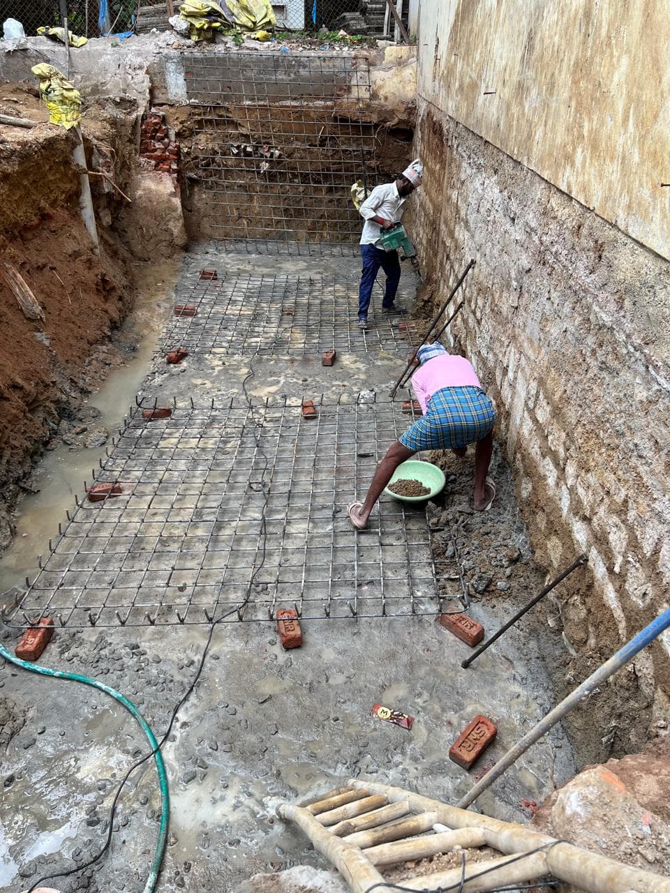 Workers binding rebar mat in the foundation pit