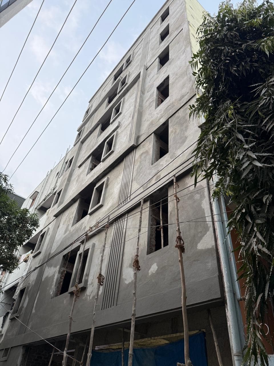 Painters completing the facade on bamboo scaffolding